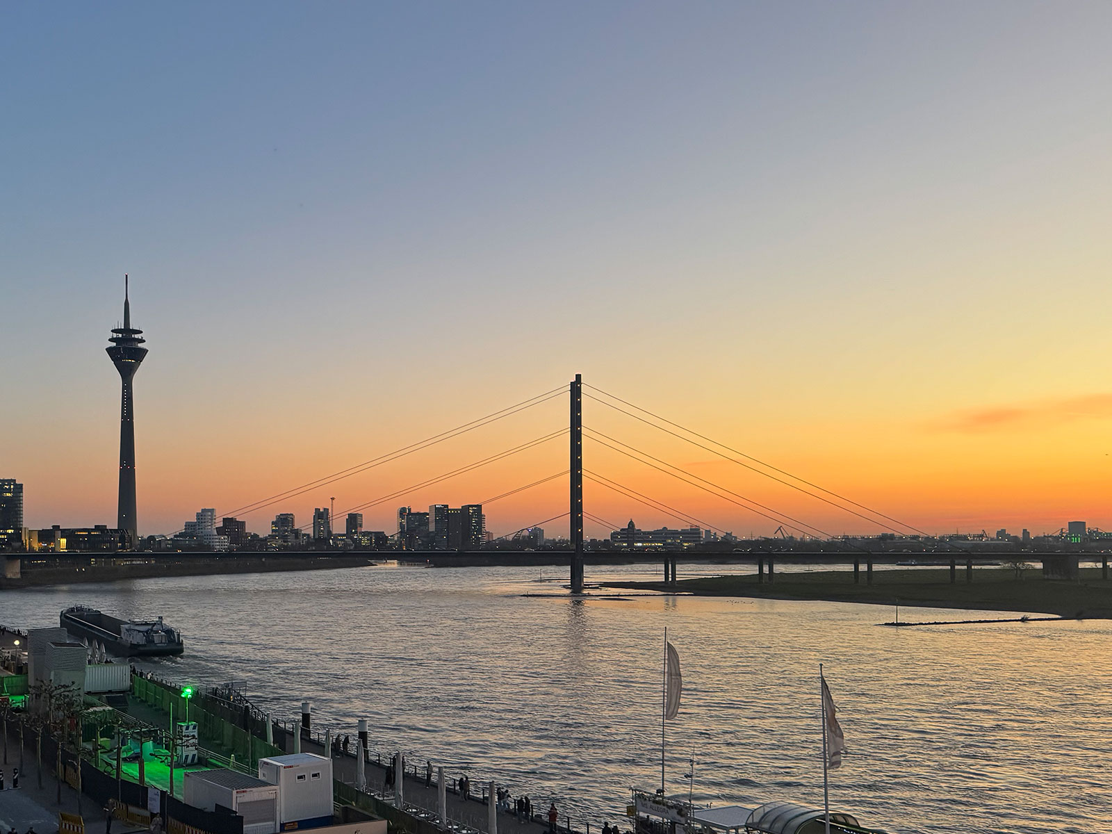 Düsseldorfer Skyline mit Rheinturm und Rheinkniebrücke im Sonnenuntergang